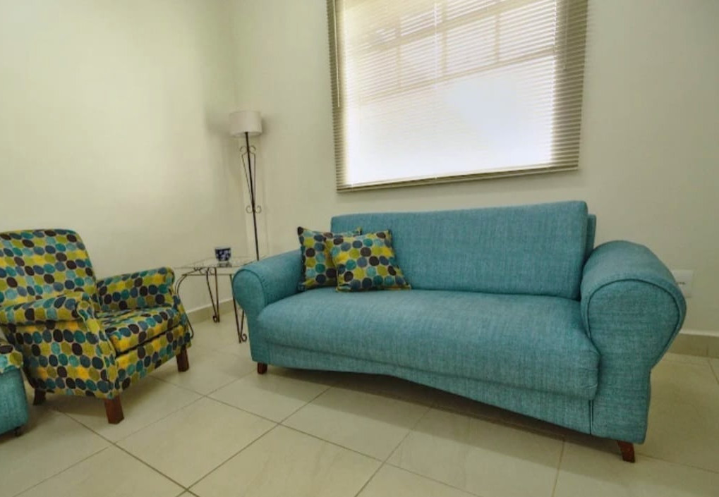 Sala de espera do consultório, com sofá e poltrona em tons de azul